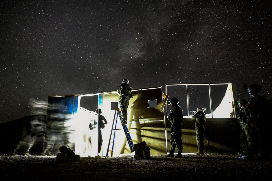 Soldiers train at night, conducting a live-fire shoot in a house.