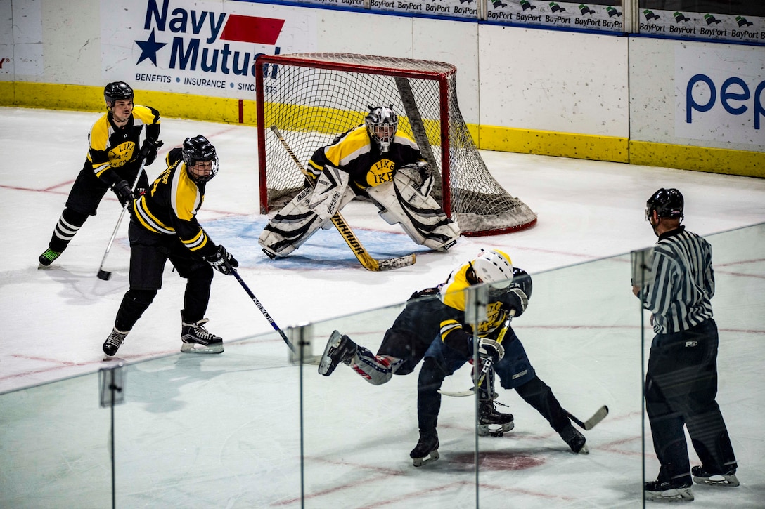 Hockey players from two ships play a game on the ice.