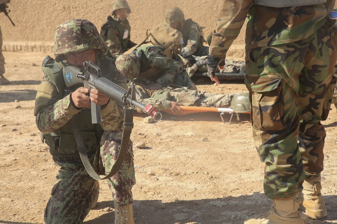 An Afghan National Army soldier with 6th Kandak, 1st Brigade, 215th Corps holds security as two notionally wounded soldiers receive medical care during casualty evacuation training at Camp Shorabak, Afghanistan, Nov. 19, 2017. The Helmand Regional Military Training Center implemented its first iteration of CASEVAC training using Afghan air assets as part of the operational readiness cycle to help prepare its students for real-world missions. U.S. advisors assigned to various train, advise, assist commands from throughout Afghanistan observed the training in preparation for integrating standardized CASEVAC rehearsals into their unit’s ORCs. (U.S. Marine Corps photo by Sgt. Lucas Hopkins)