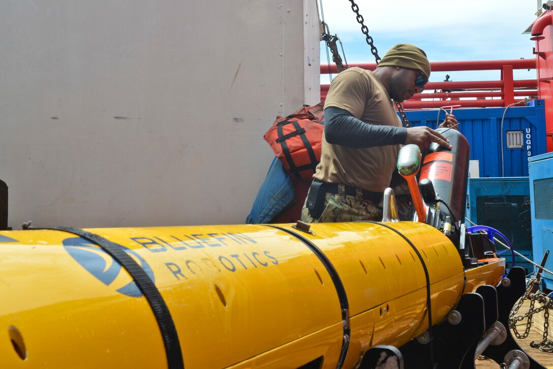 A technician performs maintenance on an unmanned underwater vehicle.