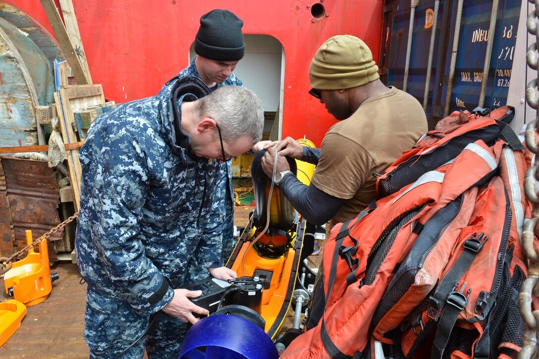 Technicians perform maintenance on an unmanned underwater vehicle.