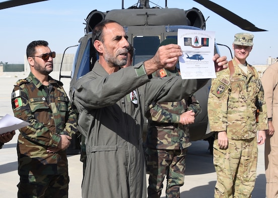 An Afghan Air Force pilot receives a certificate during a UH-60 Black Hawk Aircraft Qualification Training graduation ceremony at Kandahar Airfield, Afghanistan, Nov. 20, 2017. The pilot is one of six to be the first AAF Black Hawk pilots. The first AAF Black Hawk pilots are experienced aviators coming from a Mi-17 background. For future Black Hawk pilots the UH-60 flight training is approximately 16 weeks long, six weeks for Aircraft Qualification Training (AQT) and 10 weeks for Mission Qualification Training (MQT).  (U.S. Air Force photo by Tech. Sgt. Veronica Pierce)