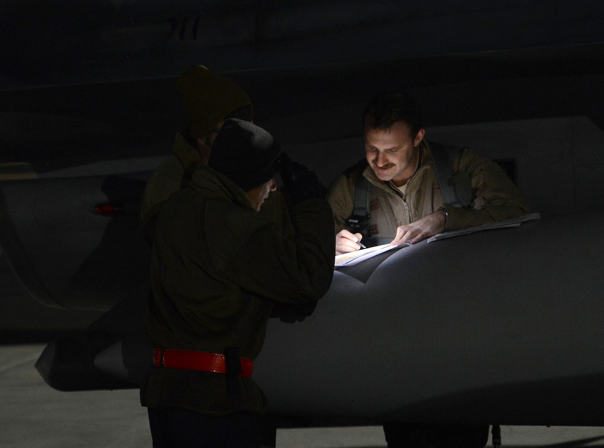 U.S. pilot assigned to the 77th Fighter Squadron and Airmen with the 455th Expeditionary Aircraft Maintenance Squadron look at flight plans Nov. 21, 2017 at Bagram Airfield, Afghanistan.
