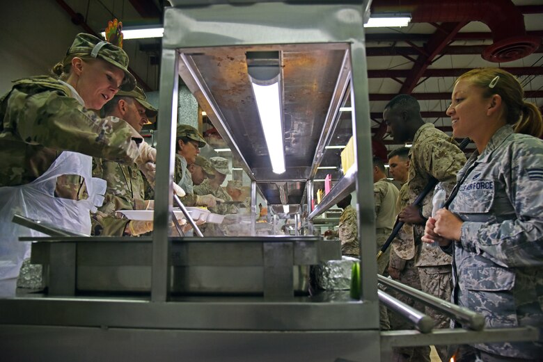 407th Air Expeditionary Group leadership serve deployed members a Thanksgiving meal at the Huntley Dining Facility on the 407th AEG in Southwest Asia, Nov. 23, 2017. Group leadership provides this Thanksgiving meal annually to help boost morale around the holiday. (U.S. Air Force photo by Staff Sgt. Joshua Edwards/Released)