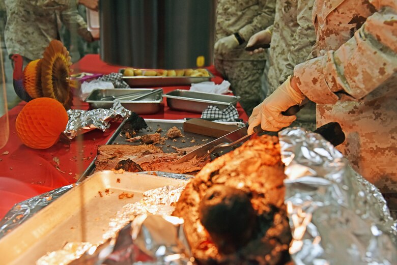 A Special Purpose Marine Air-Ground Task Force – Crisis Response – Central Command leader associated with the 407th Air Expeditionary Group cuts roast beef during the Thanksgiving meal at the Huntley Dining Facility on the 407th AEG in Southwest Asia, Nov. 23, 2017. Group leadership spent part of their day serving deployed service members, coalition partners and contractors holiday meals. (U.S. Air Force photo by Staff Sgt. Joshua Edwards/Released)