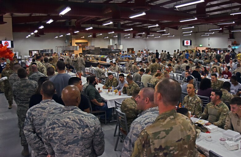 Service members wait in line while others eat their Thanksgiving meal at the Huntley Dining Facility on the 407th Air Expeditionary Group in Southwest Asia, Nov. 23, 2017. 407th AEG leadership came together to serve roast beef, ham and turkey to deployed personnel. (U.S. Air Force photo by Staff Sgt. Joshua Edwards/Released)
