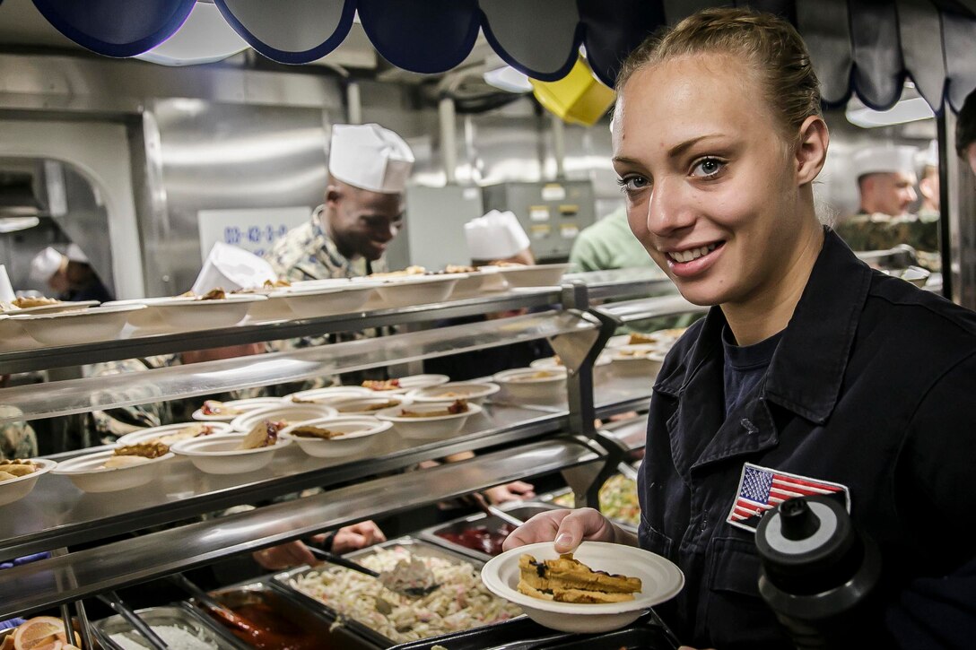 U.S. Marines and Sailors with Fox Company, Battalion Landing Team, 2nd Battalion, 6th Marine Regiment, 26th Marine Expeditionary Unit (MEU) and Sailors assigned to the dock landing ship USS Oak Hill (LSD 51), serve a Thanksgiving meal to personnel aboard the Oak Hill, during Combined Composite Training Unit Exercise (COMPTUEX).