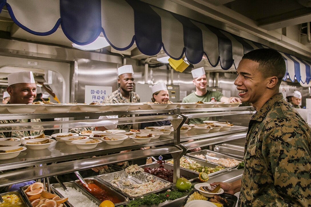 U.S. Marines and Sailors with Fox Company, Battalion Landing Team, 2nd Battalion, 6th Marine Regiment, 26th Marine Expeditionary Unit (MEU) and Sailors assigned to the dock landing ship USS Oak Hill (LSD 51), serve a Thanksgiving meal to personnel aboard the Oak Hill, during Combined Composite Training Unit Exercise (COMPTUEX).