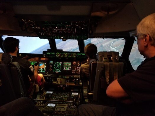 A group of honorary commanders and civic leaders got to experience flight in the C-5M Super Galaxy Simulator, during the 433rd Operations’ Group tour, Nov. 18, 2017, on Joint Base San Antonio, Texas. Alex Ridolfi, is in the driver’s seat of the C-5M Simulator, with instructor Major Brandi Cone in the instructor’s seat, while Simulator Instructor, Steve Bilyeu oversees the whole operation. (U.S. Air Force photo by Minnie Jones)