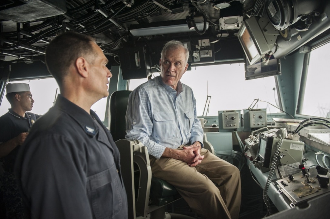 Secretary of the Navy Richard V. Spencer speaks to Capt. Joseph Olson, the commanding officer of the amphibious assault ship USS America, on the bridge during his visit on Thanksgiving Day.