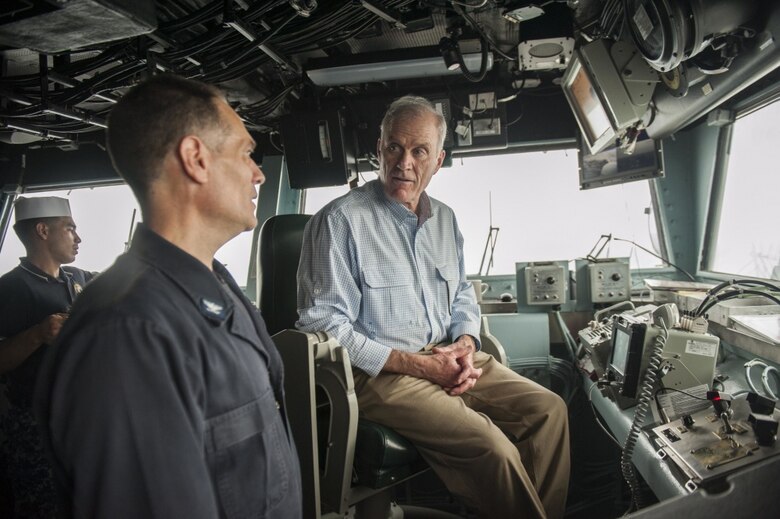 Secretary of the Navy Richard V. Spencer speaks to Capt. Joseph Olson, the commanding officer of the amphibious assault ship USS America, on the bridge during his visit on Thanksgiving Day.