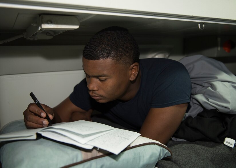 Navy Petty Officer 3rd Class Antwoun Stevens writes poetry in his rack aboard the guided-missile cruiser USS Lake Erie, Oct. 19, 2017. Navy photo by Petty Officer 3rd Class Lucas T. Hans