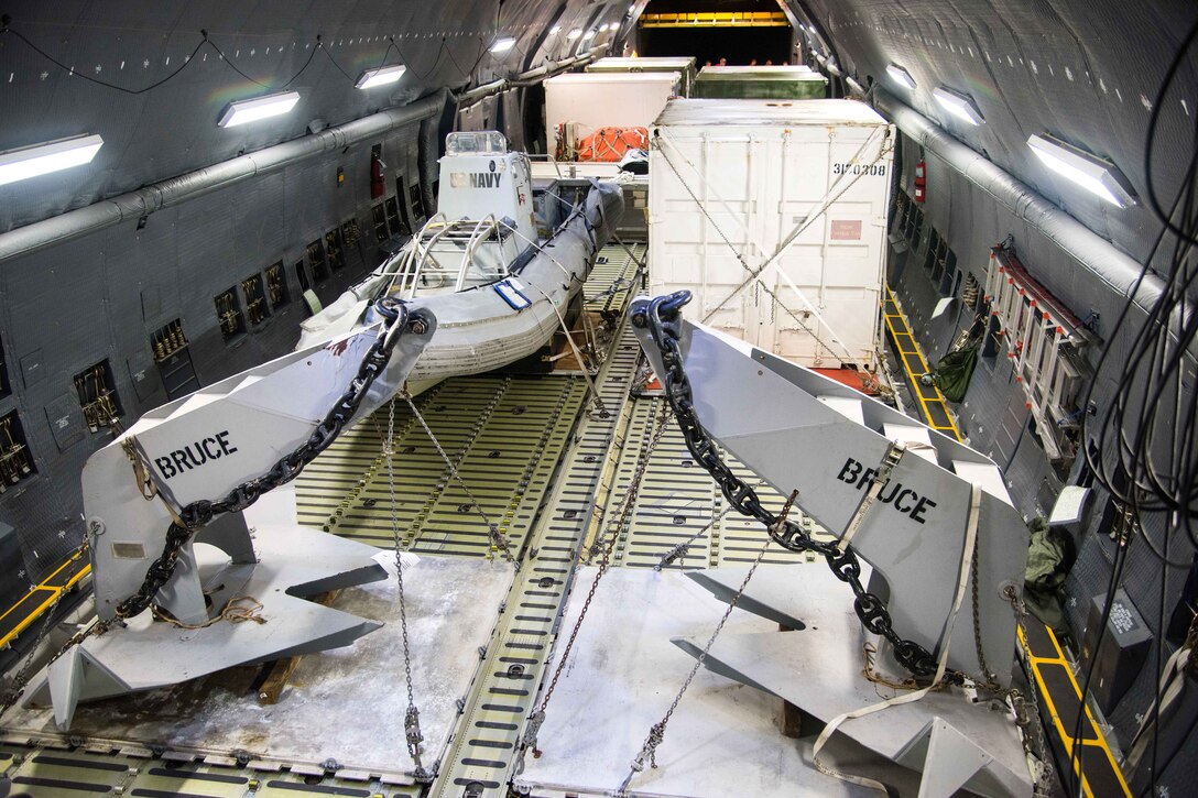 Air Force personnel secure Navy equipment after being uploaded onto a military aircraft.