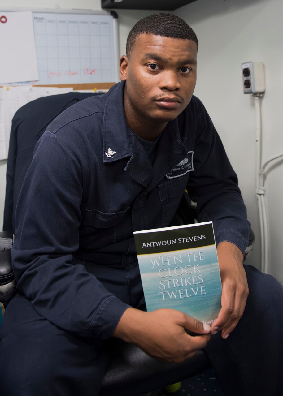 Navy Petty Officer 3rd Class Antwoun Stevens holds a copy his self-published book aboard the guided-missile cruiser USS Lake Erie, Oct. 19, 2017. Navy photo by Petty Officer 3rd Class Lucas T. Hans