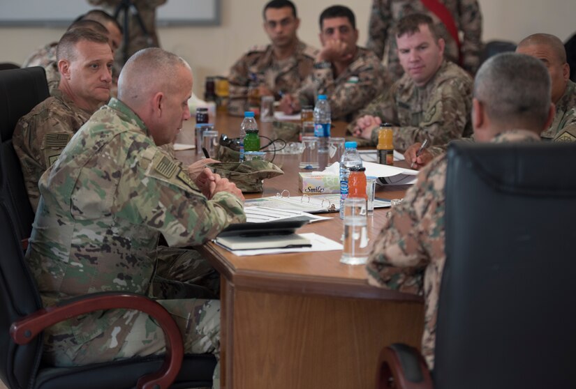 Soldiers sitting around a table in a meeting.