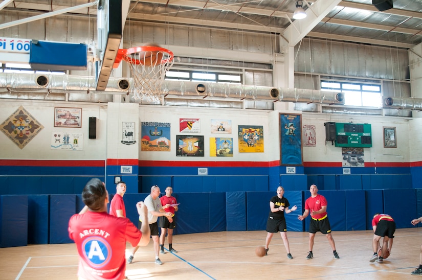 Men and women playing basketball in a gym.
