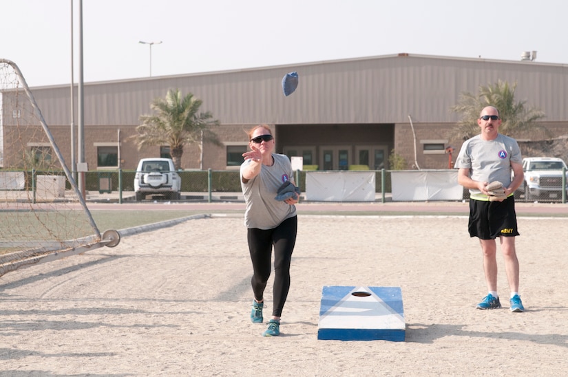 Two soldiers playing a bean bag toss game.