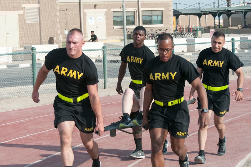 Soldiers carrying a litter around a track.