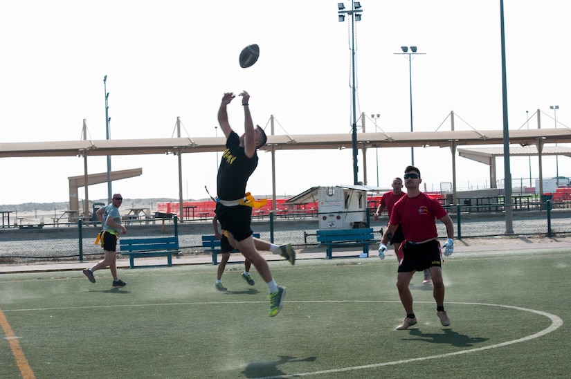 Several soldiers playing flag football.