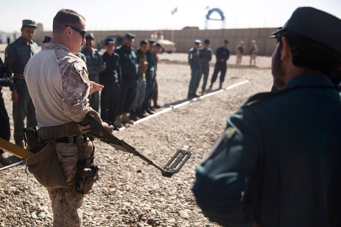 A U.S. Marine shows how to setup the metal detector during a train, advise and assist mission.