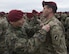 A Serbian paratrooper trades jump wings with a U.S. Army paratrooper assigned to the 173rd Airborne Brigade on Lisicji Jarak Airport, Serbia, Nov. 17, 2017. U.S. and Serbian paratroopers traded jump wings as a symbol of goodwill after conducting five days of airborne insertion exercises together during Exercise Double Eagle. (U.S. Air Force photo by Senior Airman Elizabeth Baker)