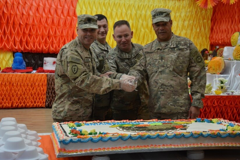 Officers pose for a photo while cutting the cake.