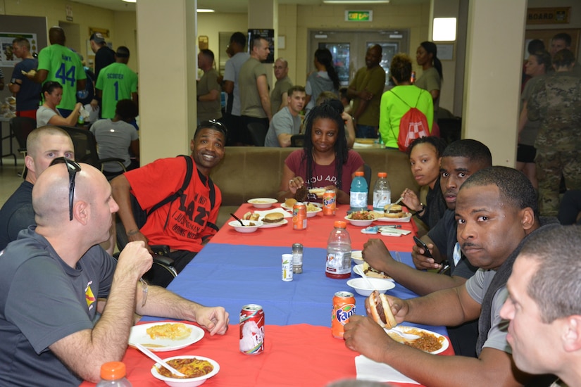 Soldiers around a table eating a meal.