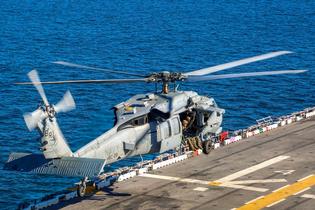 A Navy MH-60S Seahawk helicopter takes off with Marines from the amphibious assault ship USS Iwo Jima.