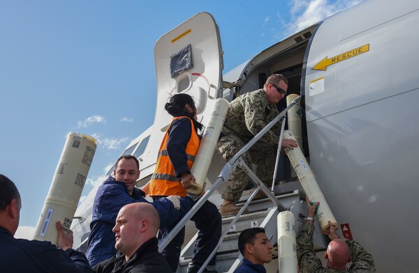 Sailors load sonobouys onto a P8-A Poseidon aircraft.