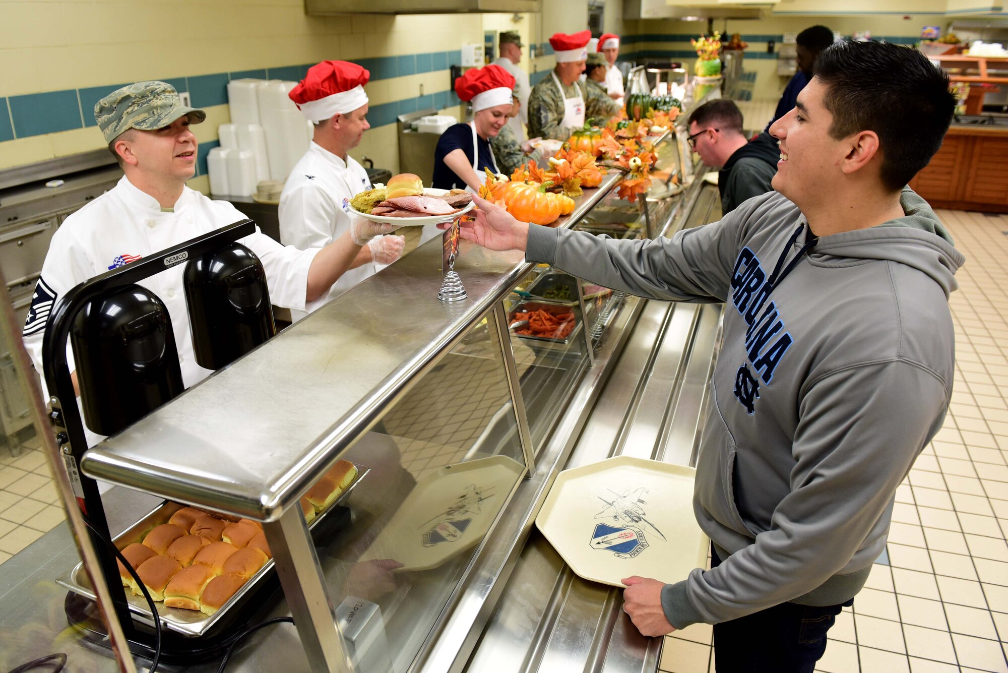 Master Sgt. Joshua McLaughlin, 4th Force Support Squadron first sergeant, serves a meal to Airman Christian Ramirez, F-15E Strike Eagle student crew chief, at the 4th FSS dining facility Nov. 23, 2017, at Seymour Johnson Air Force Base, North Carolina. Base leaders helped serve more than 150 meals to dining facility guests on Thanksgiving Day. (U.S. Air Force photo by Airman 1st Class Kenneth Boyton)