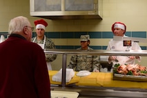Col. Christopher Sage, 4th Fighter Wing commander, right; Airman 1st Class Kristal Montalvo, 4th Force Support Squadron food service worker, center and Chief Master Sgt. William Adams, 4th FW command chief, left, help serve a Thanksgiving holiday meal to Airmen and dining facility attendees at the Seymour Johnson Air Force Base 4th FSS dining facility Nov. 23, 2017, at Seymour Johnson AFB, North Carolina. Base leaders helped serve more than 150 meals to dining facility guests on Thanksgiving Day.  (U.S. Air Force photo by Airman 1st Class Kenneth Boyton)