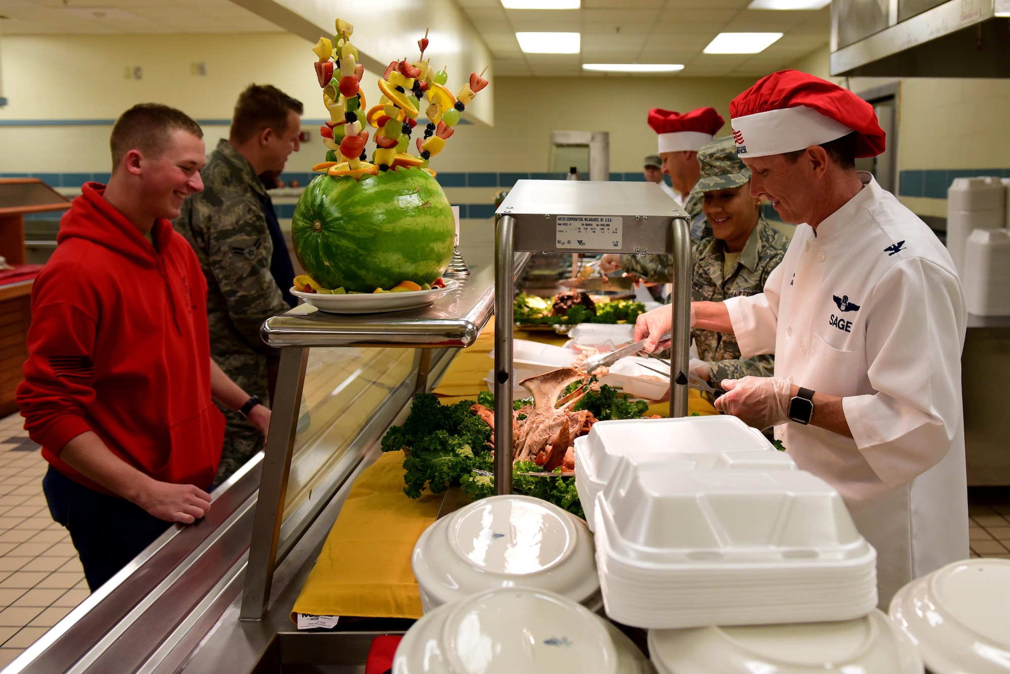 Col. Christopher Sage, 4th Fighter Wing commander, serves turkey to Airman Luke Heinl, F-15E Strike Eagle student crew chief, at the 4th Force Support Squadron dining facility Nov. 23, 2017, at Seymour Johnson Air Force Base, North Carolina. Base leaders helped serve more than 150 meals to dining facility guests on Thanksgiving Day. (U.S. Air Force photo by Airman 1st Class Kenneth Boyton)