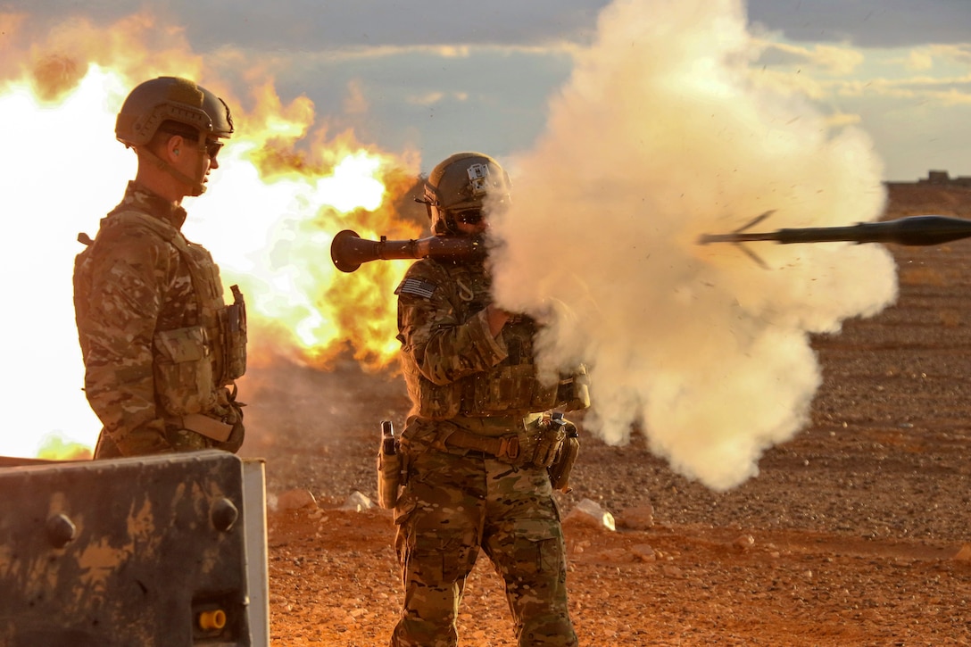 Two soldiers fire a weapon.