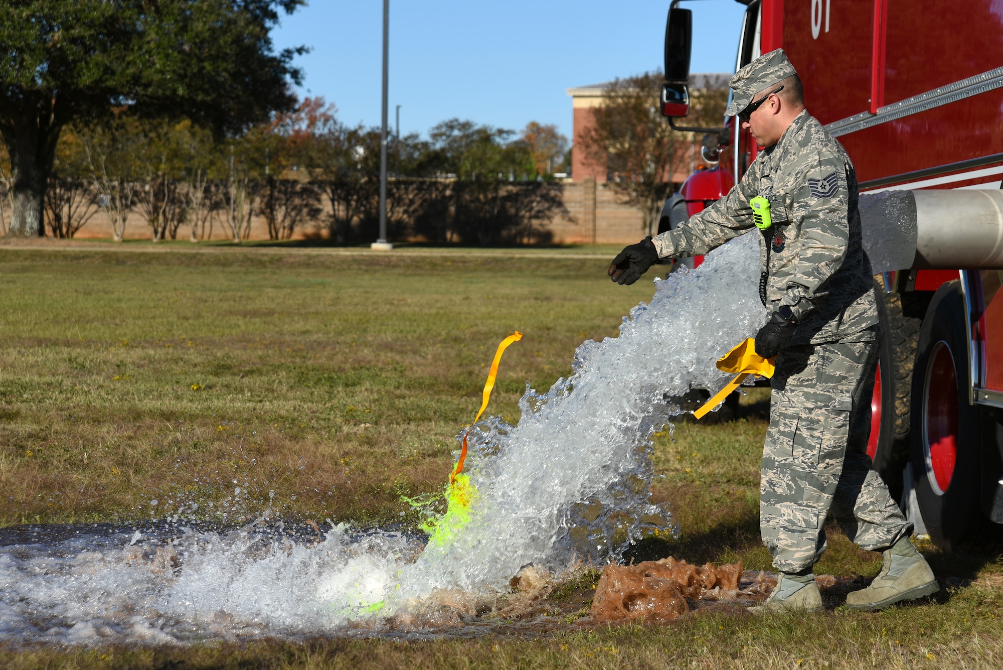 U.S. Air Force Tech. Sgt. Larry Diaz, 20th Civil Engineer Squadron noncommissioned officer in charge of training, tosses a dye packet into water being emptied from a fire truck during a major accident response exercise at Shaw Air Force Base, South Carolina, Nov. 17, 2017.