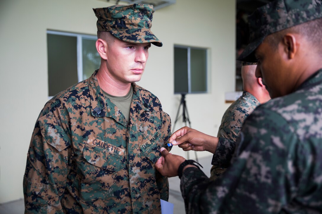 U.S. Marine Sgt. David G. Gaudette, the staff noncommissioned officer in charge of the Honduras Detachment, Ground Combat Element, Special Purpose Marine Air-Ground Task Force - Southern Command, is presented an instructor’s pin by a Honduran marine with the Batallion de Infanteria de Marina at the graduation for the Advanced Infantry Course in Trujillo, Honduras, Nov. 10, 2017. The course was designed to further enhance the skills of Honduran marines who have mastered the basics of infantry operations. The Marines and sailors of SPMAGTF-SC are concluding their deployment to Central America, during which they conducted security cooperation training and engineering projects with their counterparts in several Central American and Caribbean nations. (U.S. Marine Corps photo by Sgt. Melissa Martens)