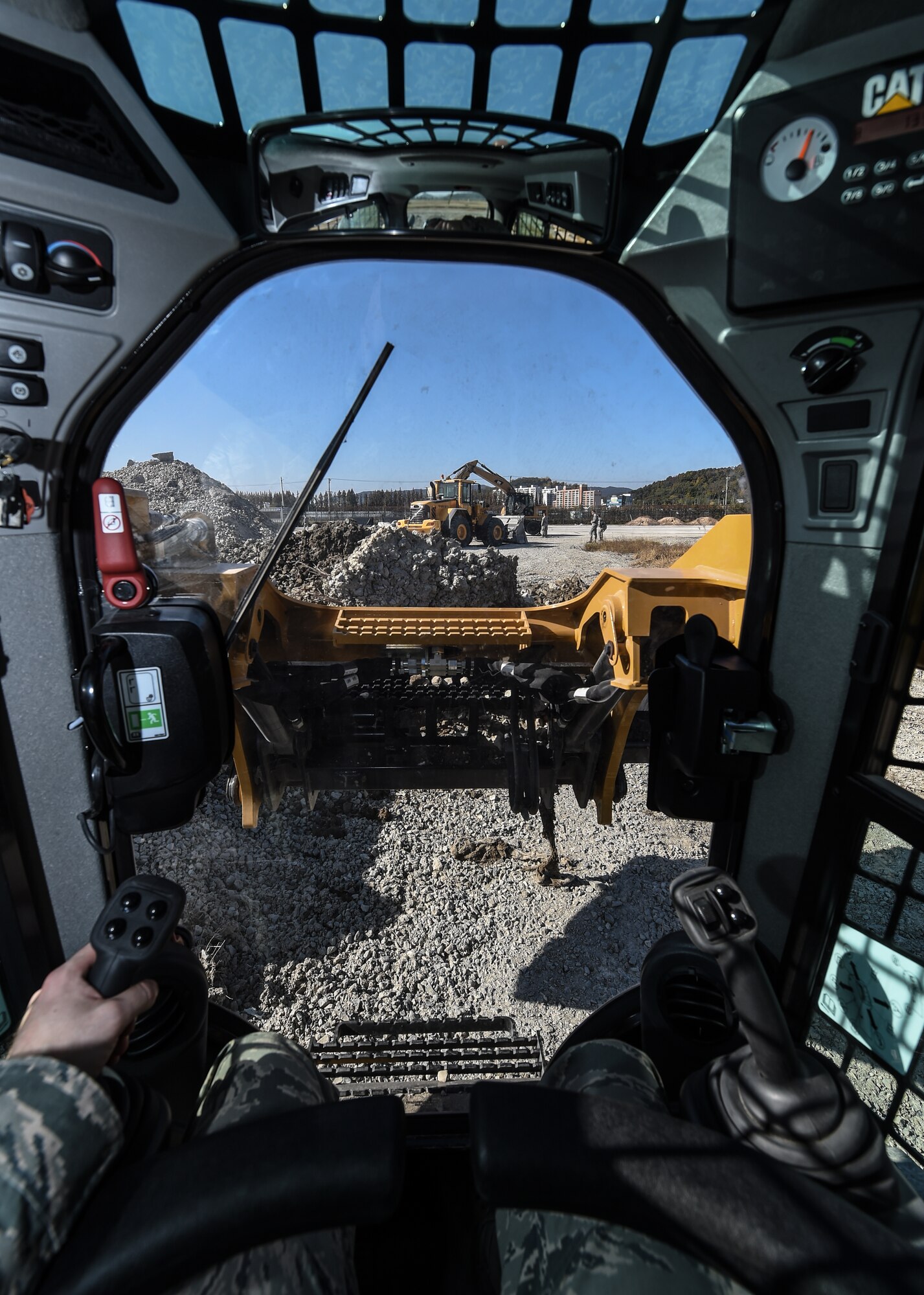 An Airman from the 673d Air Base Wing operates a compact track loader during a Rapid Airfield Damage Repair training exercise at Gwangju Air Base, Republic of Korea., Nov. 9, 2017. Approximately forty U.S. Airmen from Joint Base Elmendorf-Richardson, Alaska, and 40 R.O.K. Airmen trained together for a week to learn a new runway repair process for wartime contingencies. The bilateral training exercise enhanced interoperability and strengthen partnerships in the Indo-Asia Pacific region. (U.S. Air Force photo by Senior Airman Curt Beach)