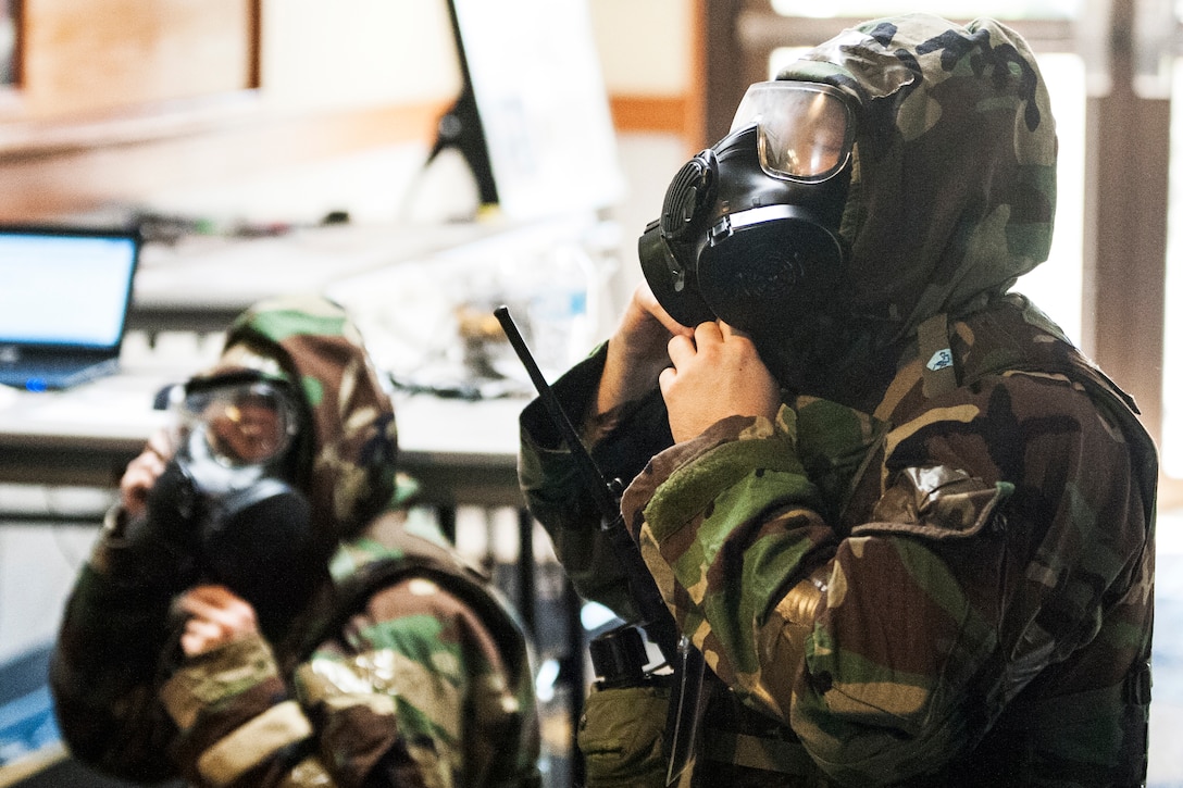 Airmen put on protective gear during exercise.