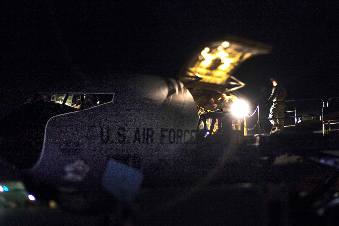 New Jersey Army National Guardsmen assist airmen unloading gear from a KC-135 Stratotanker.