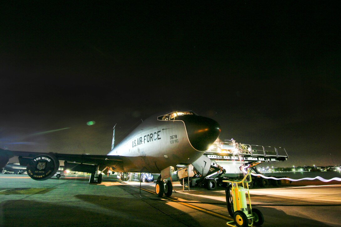 A KC-135 Stratotanker is unloaded by a 60K aircraft cargo loader.