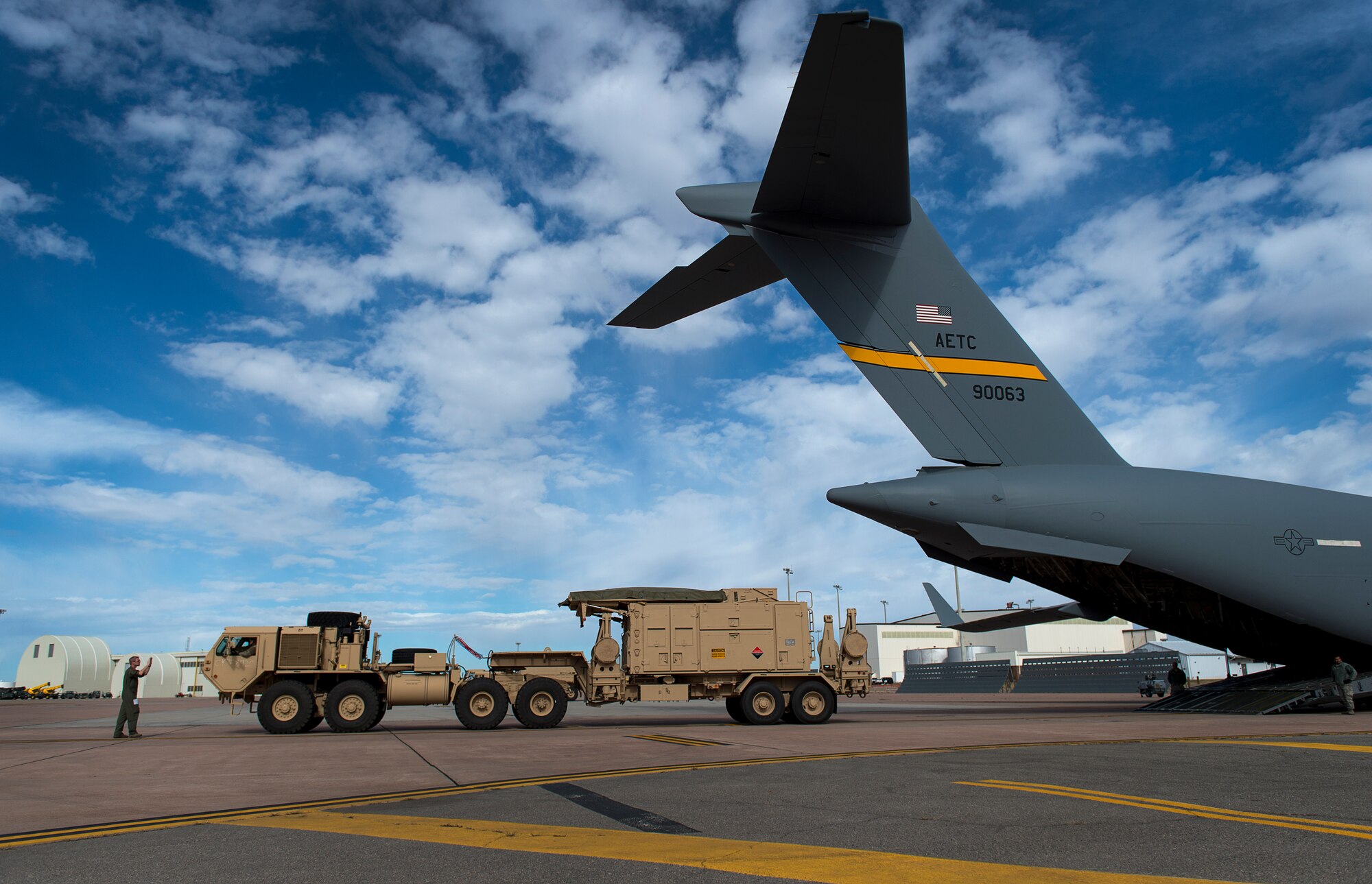 U.S. Air Force Tech. Sgt. Jerry Daniels, a loadmaster instructor with the 58th Airlift Squadron, directs a U.S. Army Soldier assigned to the 4th Battalion 3rd Air Defense Artillery Regiment, while he backs a vehicle onto a C-17 Globemaster III