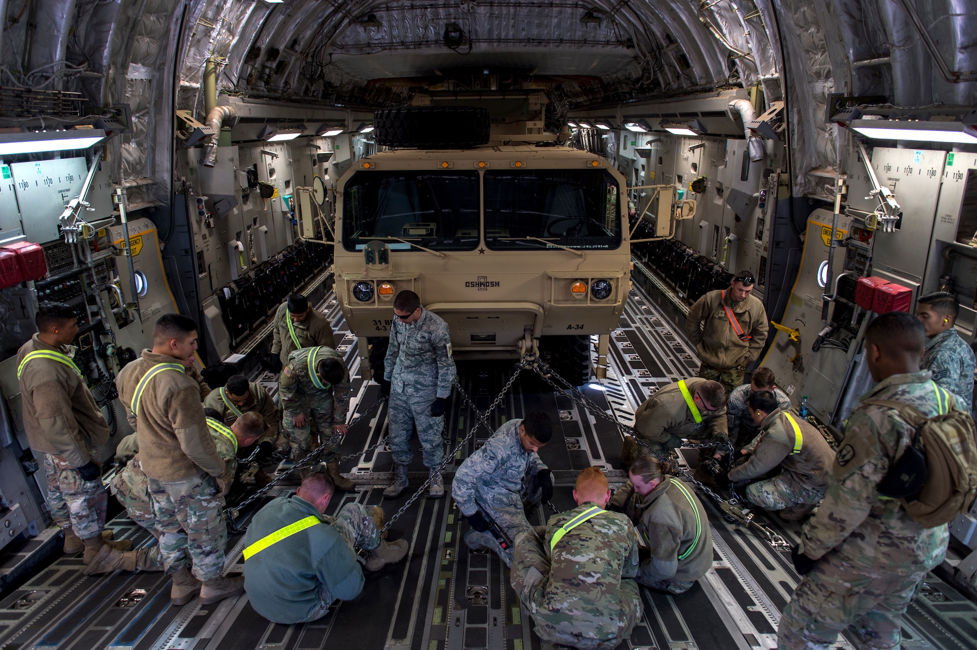 U.S. Army Soldiers assigned to Ft. Sill, Okla., and U.S. Air Force Airmen stationed at Altus Air Force Base, Okla., practice securing a vehicle inside a C-17 Globemaster III