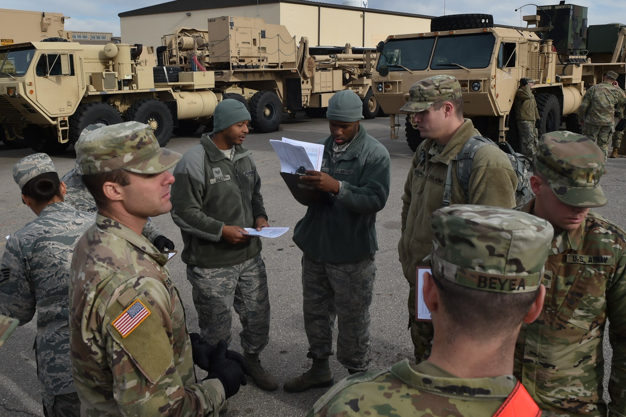 Members of the 97th Air Mobility Wing and the 4th Battalion, 3rd Air Defense Artillery Regiment prepare to inspect several vehicles during a joint exercise