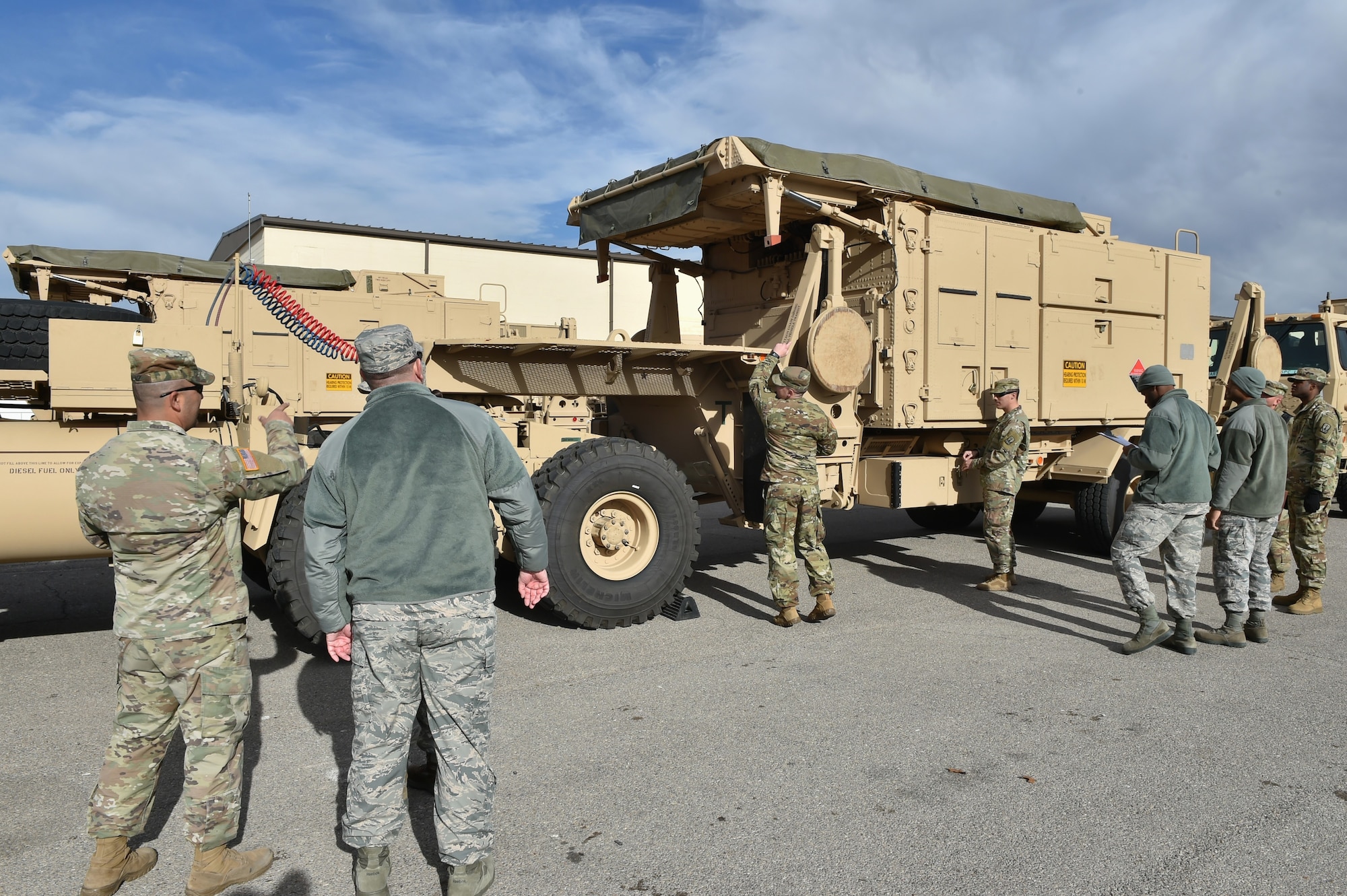 Members of the 97th Air Mobility Wing and the 4th Battalion, 3rd Air Defense Artillery Regiment inspect a vehicle during an exercise
