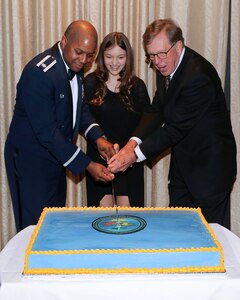 Lt. Col. Christopher Robinson, 91st Cyberspace Operations Squadron commander, Alyssa Correia, and John Reynolds III participate in the formal cutting of the cake during the 91st COS centennial dinner in San Antonio, Oct. 28, 2017. Reynolds is a surviving descendant of the 91st COS’ founding commander, Col. John Reynolds. (Courtesy photo)
