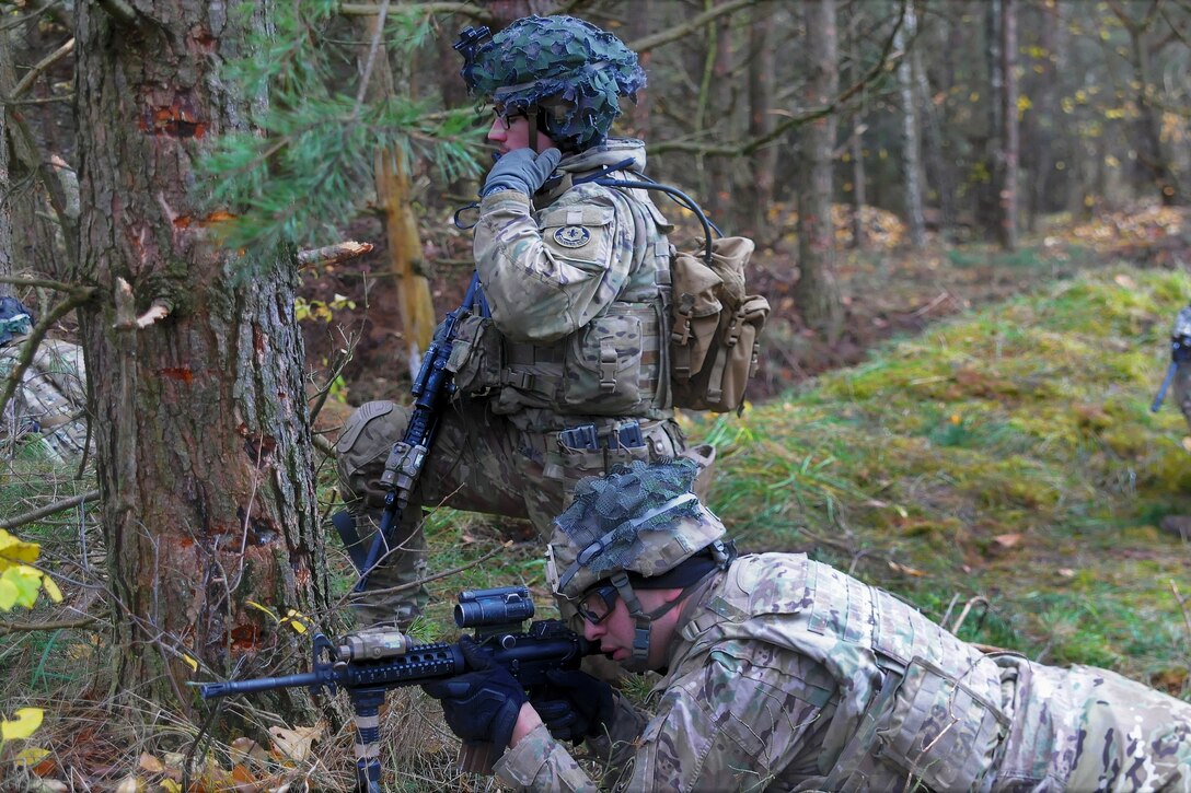 A soldier calls in a status report to his headquarters team after clearing an objective during a squad live-fire exercise.