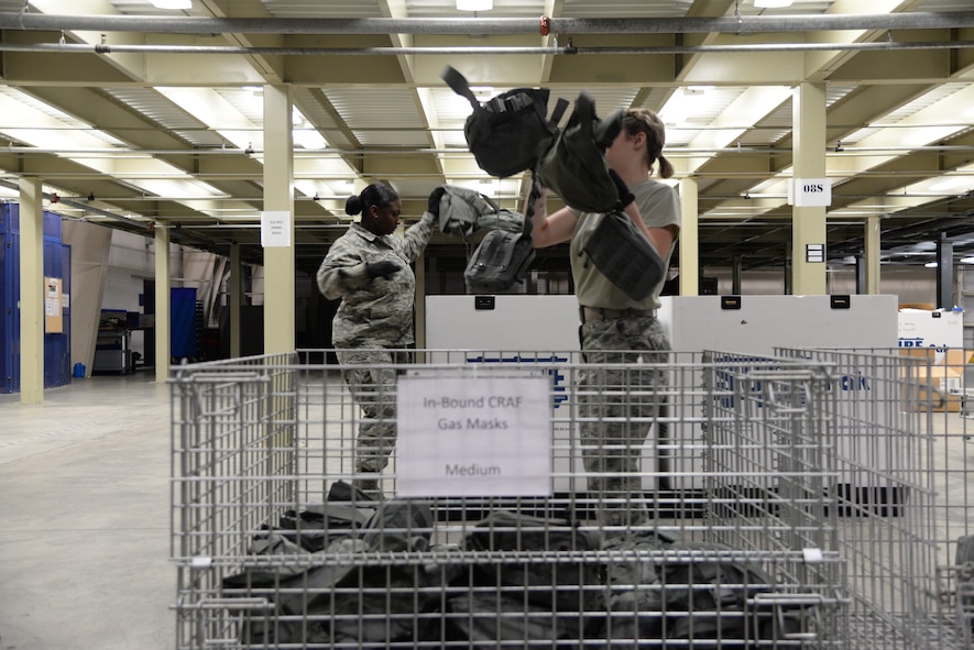 Tech. Sgt. Deanna Parsons, 436th Logistics Readiness Squadron NCO in charge of individual protective equipment, and Airman 1st Class Alizabeth Rawlings, 436th LRS materiel management technician, transfer gas masks to containers during a Civil Reserve Air Fleet readiness exercise Nov. 13, 2017, inside the IPE warehouse on Dover Air Force Base, Del. They maintained accountability for every piece of equipment ensuring no items were lost or unaccounted for. (U.S. Air Force photo by Staff Sgt. Aaron J. Jenne)