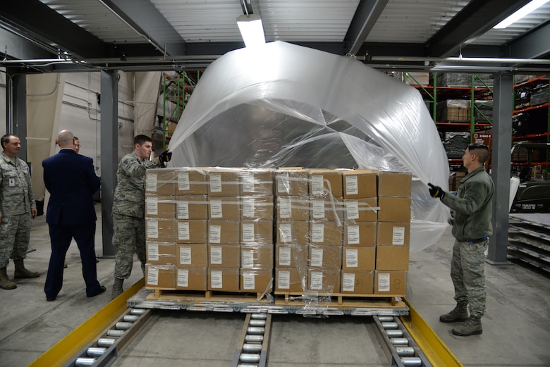 Airmen 1st Class Matthew Moneymaker-Grizzle and Ryan Chamberlain, 436th Aerial Port Squadron cargo processors, prepare a pallet of gas masks during a Civil Reserve Air Fleet readiness exercise Nov. 13, 2017, at Dover Air Force Base, Del. Each pallet was covered in plastic to protect it from the elements and strapped down to secure the contents for flight. (U.S. Air Force photo by Staff Sgt. Aaron J. Jenne)