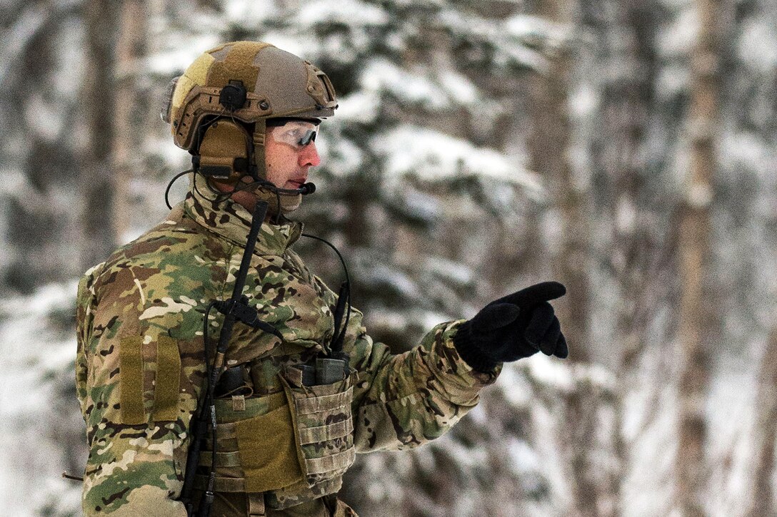 A guardsmen gives direction to soldiers.