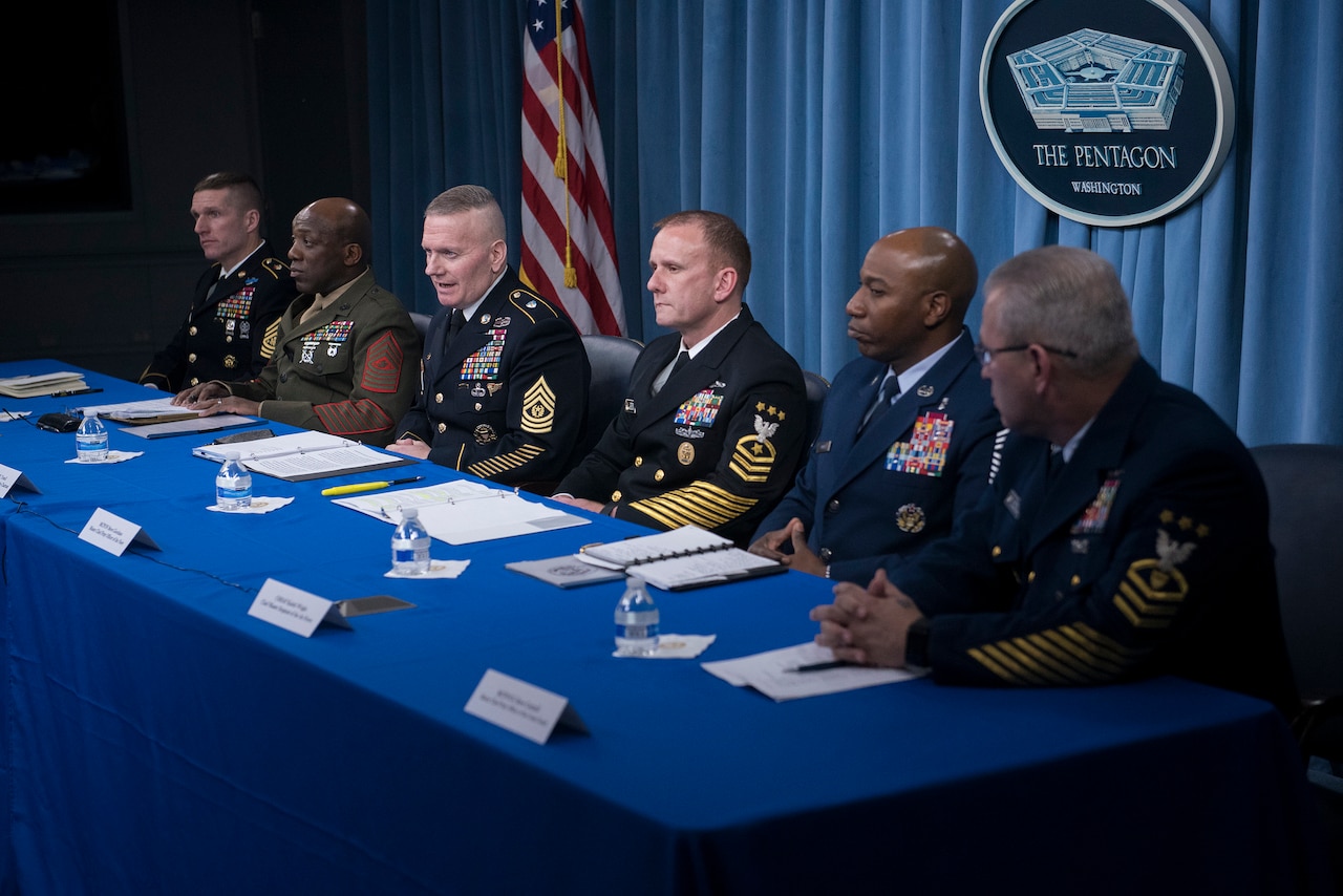 Senior enlisted service members speak with reporters.