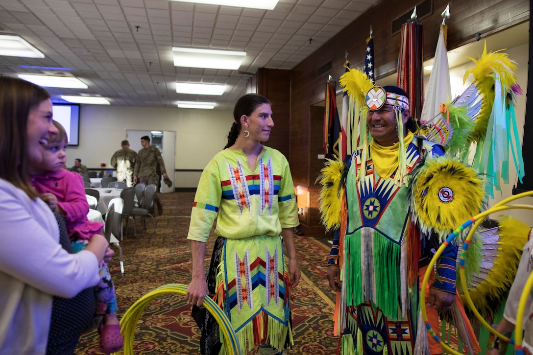 Native American dancers speak with a service member's family.